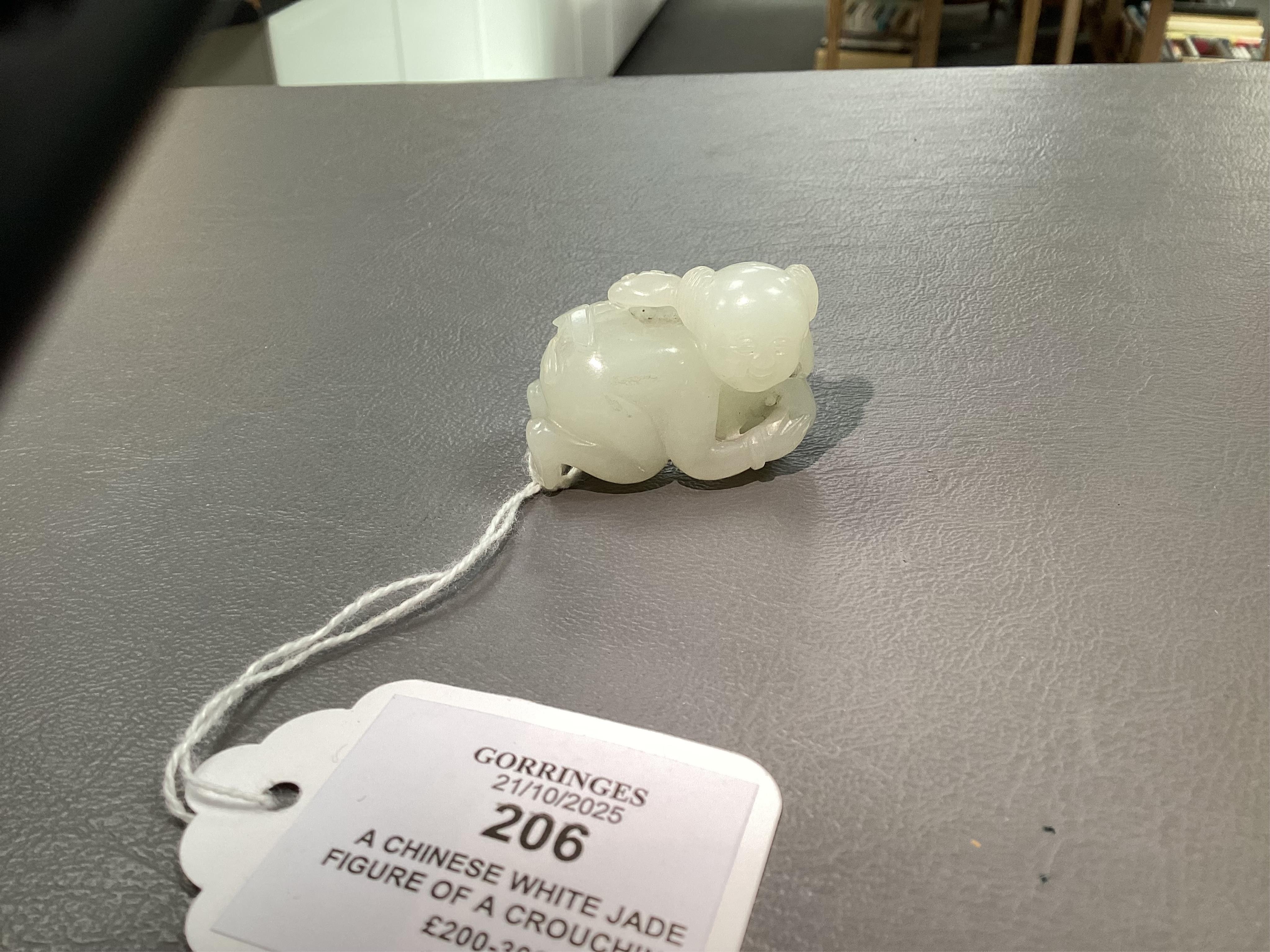 A Chinese white jade figure of a crouching boy, 19th/20th century